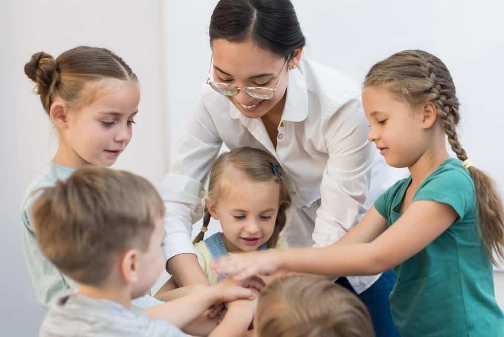 maestra juntando sus manos sus alumnos juego