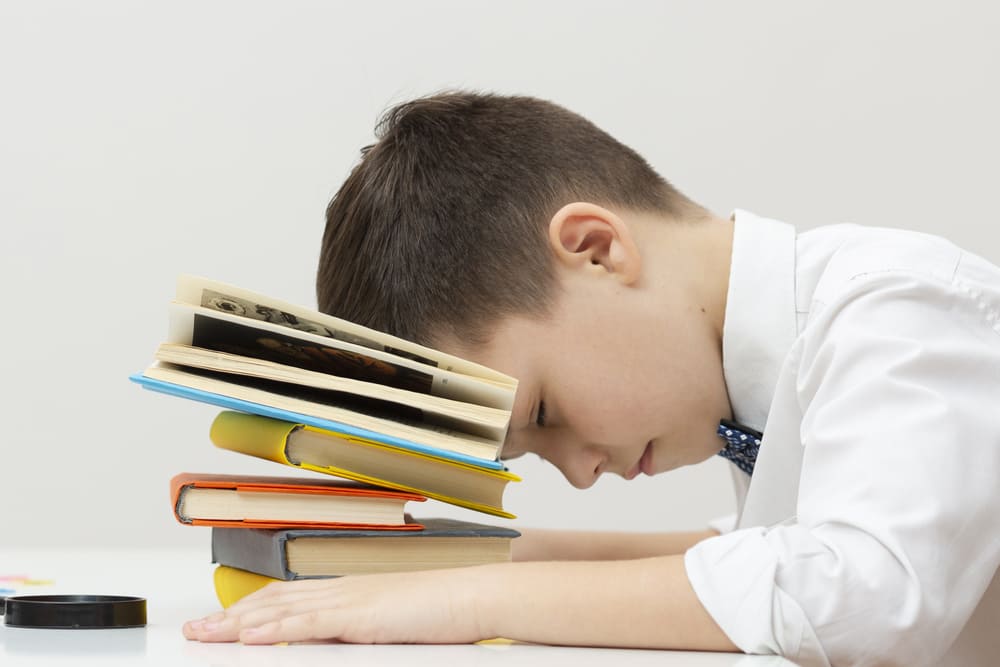 niño problemas aprendizaje sentado cabeza en libros