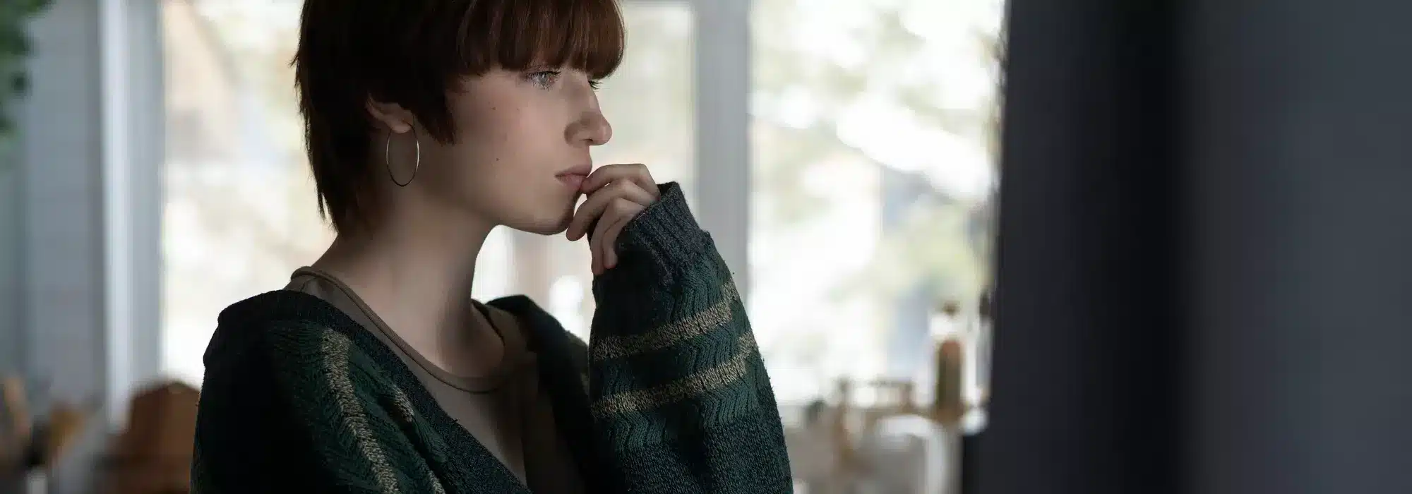 mujer triste mirando por la ventana