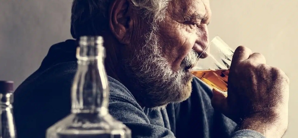 hombre mayor bebiendo alcohol