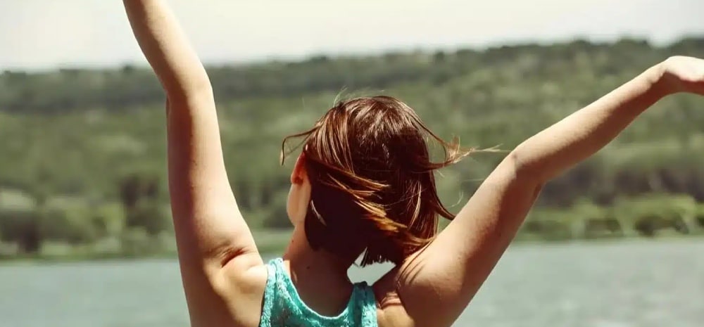 mujer contenta con los brazos levantados